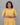 Woman wearing a yellow dress against a gray background