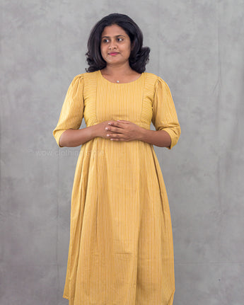Woman wearing a yellow dress against a gray background