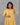 Woman wearing a yellow dress against a gray background