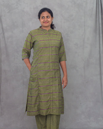 Woman wearing a green and purple striped kurti with matching pants against a gray background
