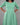 Green dress worn by a person on a gray background
