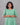 Woman wearing a green dress against a gray background