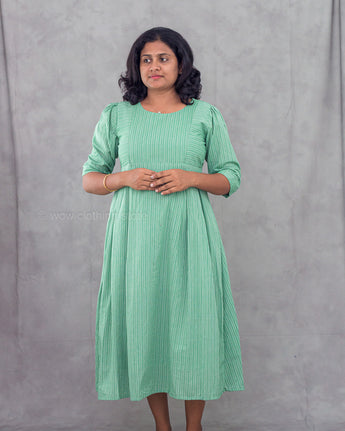 Woman wearing a green dress against a gray background