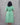 Person wearing a green dress against a gray background