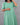 Person wearing a green dress against a gray background