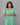 Woman wearing a green dress against a gray background