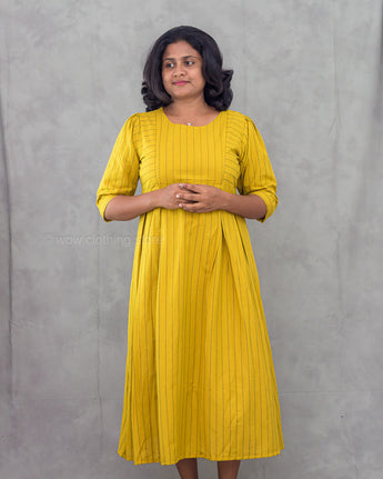 Woman wearing a yellow dress against a gray background