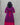 Person wearing a purple dress with a pink belt against a gray background