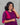 Woman wearing a purple and pink traditional outfit against a gray background