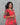 Woman wearing a red and green patterned dress against a gray background