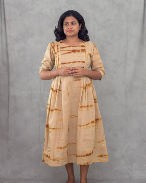 Women wearing a beige tie dye patterned kurta against a gray background