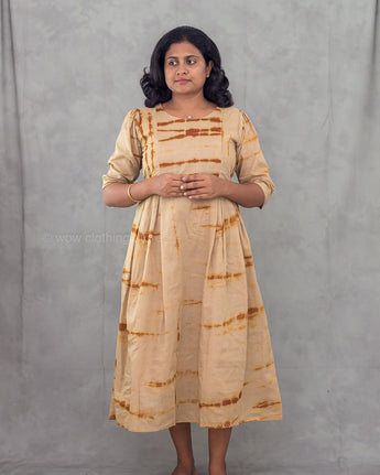 Women wearing a beige tie dye patterned kurta against a gray background
