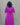 Person wearing a purple dress with white patterns against a gray background