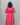 Person wearing a red dress with a belt against a gray background