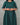 Person wearing a green dress with white patterns against a gray background