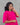 Woman wearing a bright pink traditional maternity outfit with white patterns against a gray background