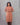 Woman wearing a brown kurta against a gray background