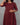 Maroon checkered dress worn by a person against a gray background