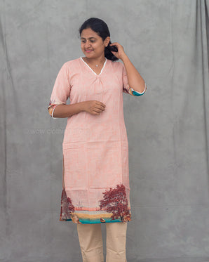 Woman wearing a pink kurti with a gray background