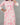 A women wearing a floral printed lace work pink color top with plain beige bottom on a grey background