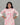 A women wearing a floral printed lace work pink color top with plain beige bottom on a grey background