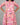 Person wearing a pink floral dress against a gray background
