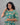 Woman wearing a green floral dress against a gray background