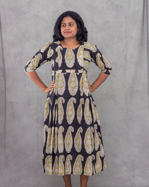 Woman wearing a patterned dress against a plain background
