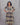 Woman wearing a patterned dress against a plain background