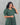 Woman wearing a green patterned dress against a gray background