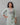 A lady wearing a plain top with elegant neck work linen kurti on a grey background