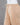 Beige pants on a mannequin against a gray background
