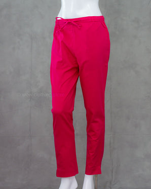 Bright pink cotton pants on a mannequin against a gray background