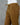 Brown cotton pants on a mannequin against a gray background