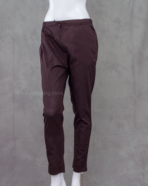 Deep brown cotton pants on a mannequin against a gray background