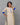 Woman wearing a cream kurta with blue accents against a gray background