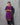 Woman wearing a purple kurta with a black dupatta draped over her shoulder against a gray background