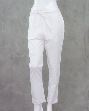 White cotton pants on a mannequin against a gray background