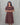 Woman wearing a brown maternity kurti against a gray background
