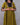 Woman wearing a green dress with black sleeves against a gray background