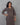 Woman wearing a patterned dress against a gray background