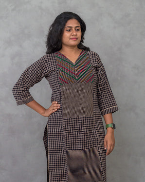 Woman wearing a patterned dress against a gray background
