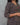 Person wearing a patterned kurta against a gray background