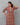 Woman wearing a patterned dress against a gray background
