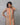 Woman wearing a brown kurta with colorful stripes against a gray background