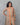Woman wearing a beige kurta with colorful stripes against a gray background