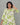 Woman wearing a green and white patterned dress against a gray background