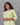 Woman wearing a green and white patterned kurti against a gray background