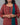 Woman wearing a red floral patterned kurta with a green dupatta against a gray background
