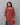 Woman wearing a maroon patterned kurti suit against a gray background